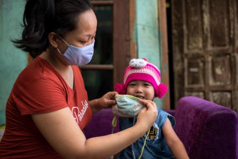 Ibu Endah, membantu Fatima, putrinya yang berusia tiga tahun menggunakan masker kain saat akan pergi keluar rumah di daerah Bekasi, Jawa barat 14 Juni 2020. Foto UNICEF/2020/Arimacs Wilander